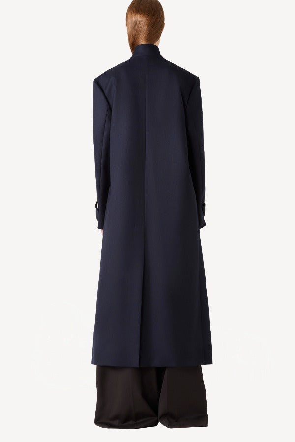 Back view of navy l/s wool lauren trench coat on model wearing black pants, against a white background.