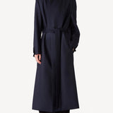 Alternate front view of navy l/s wool lauren trench coat on model wearing black pants, against a white background.