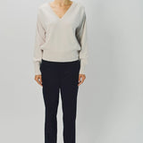 Front view of nude lavina v-neck cashmere sweater on model wearing black pants and flats, against a white background.