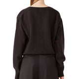 Back view of brown lavinia v-neck sweater on model wearing brown pants, against a white background.