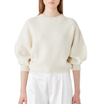 Front view of ivory mina cashmere bat wing sweater on model wearing white pants, against a white background