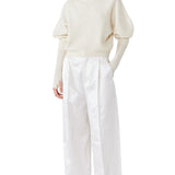 Front view of ivory mina cashmere bat wing sweater on model wearing white pants, against a white background.