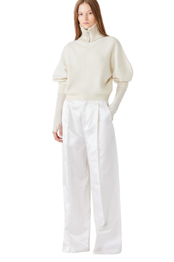 Front view of ivory mina cashmere bat wing sweater on model wearing white pants, against a white background.