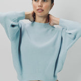 Front closeup view of cielo mina cashmere bat wing sweater on model wearing black pants, against a white background.