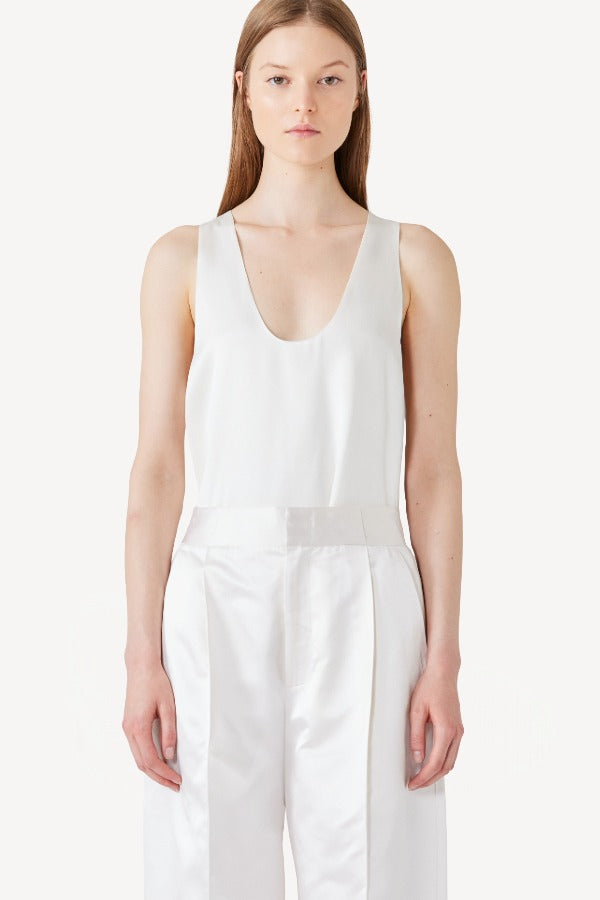 Front view of ivory S/L Silk/Viscose Tank top on model wearing white pants, against a white background.