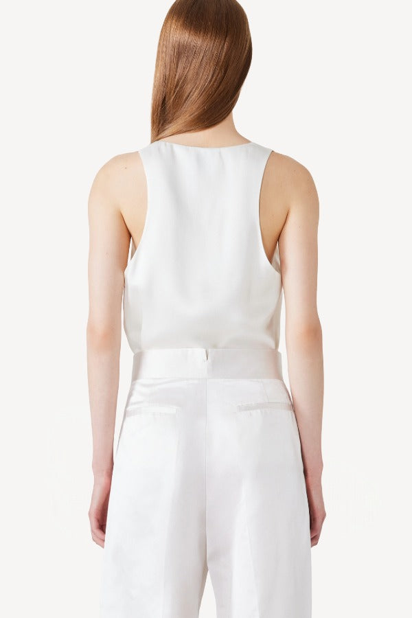 Back view of ivory S/L Silk/Viscose Tank Top on model wearing white pants, against a white background.