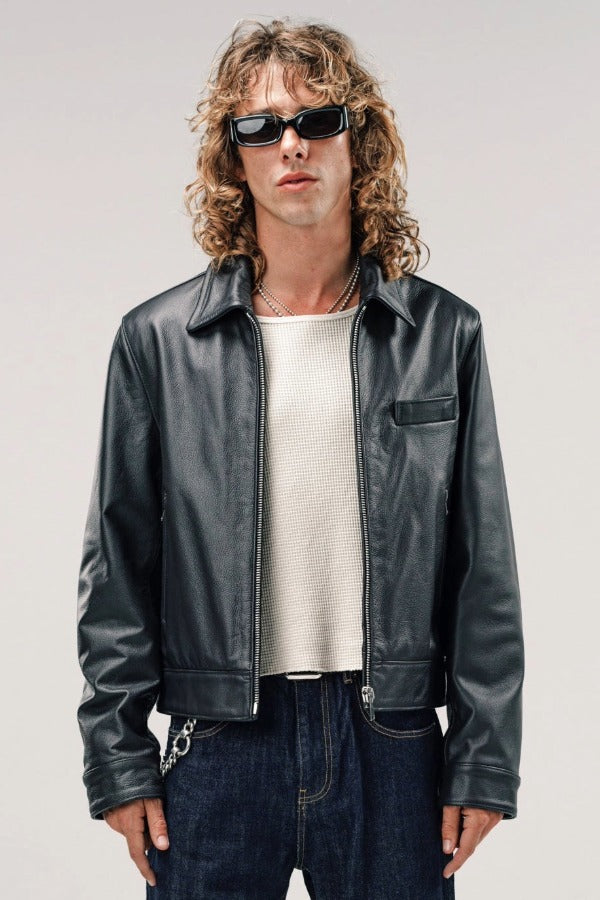 Front view of black ant de padovane jacket on model wearing white shirt and jeans, against a white background.