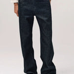 Front view of black big papi denim on model wearing white shirt and boots, against a white background.