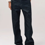 Front view of black big papi denim on model wearing white shirt and boots, against a white background.