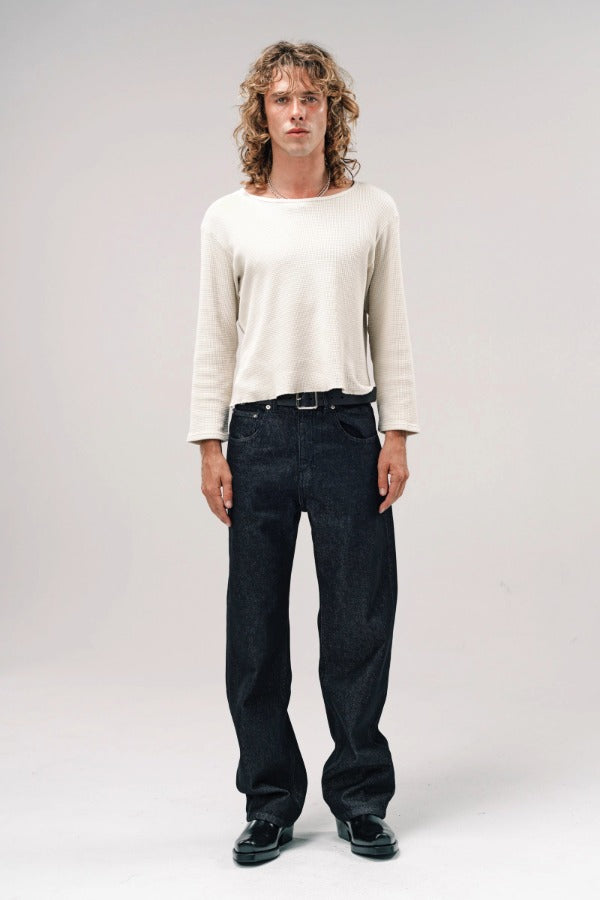 Alternate front view of black papi denim on model wearing white shirt and boots, against a white background.