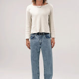Alternate front view of stone wash big papi denim pants on model wearing white shirt and boots, against a white background.