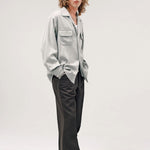 Side view of grey speckle church shirt on model wearing white shirt, grey pants and boots, against a white background.