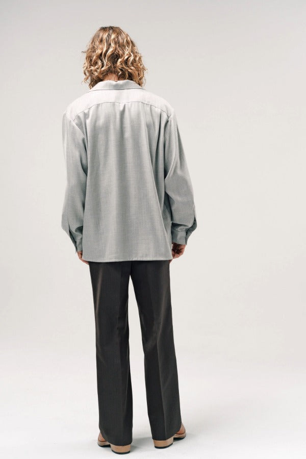 Back view of grey speckle church shirt on model wearing grey pants and boots, against a white background.