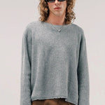 Front view of dove grey friends pullover sweater on model wearing brown pants, against a white background.