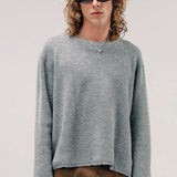 Front view of dove grey friends pullover sweater on model wearing brown pants, against a white background.