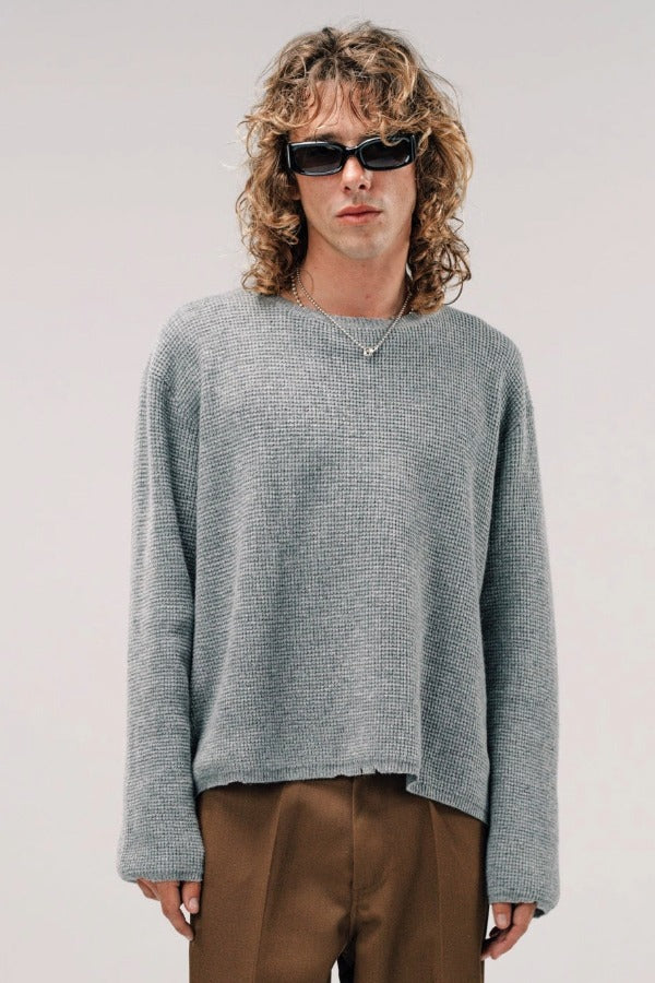 Front view of dove grey friends pullover sweater on model wearing brown pants, against a white background.