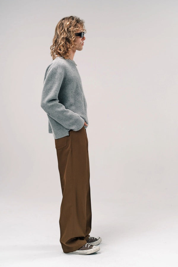 Side view of dove grey friends pullover sweater on model wearing brown pants and sneakers, against a white background.