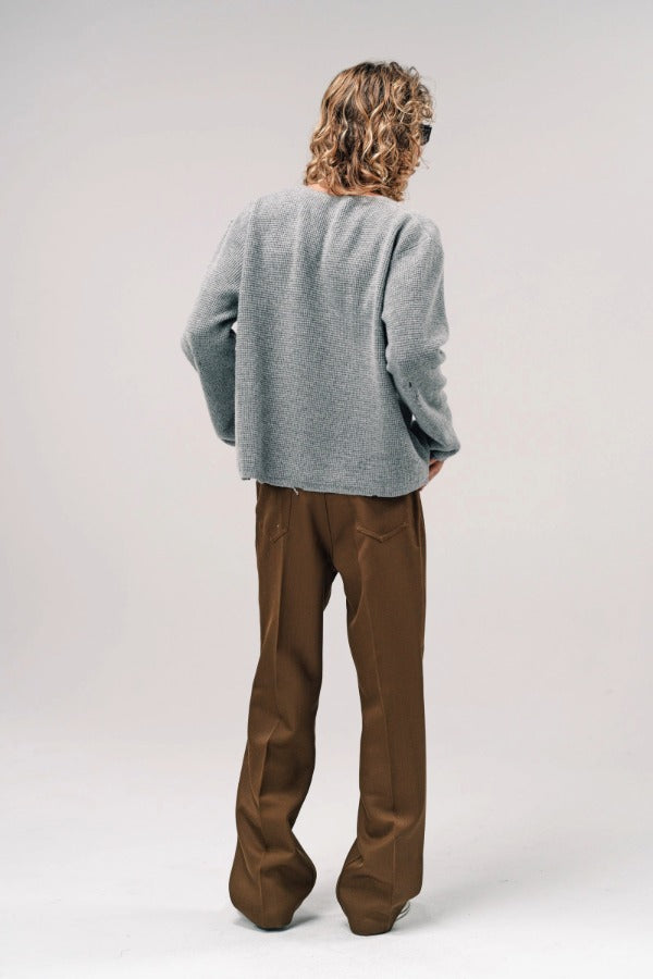 Back view of dove grey friends pullover sweater on model wearing brown pants and sneakers, against a white background.