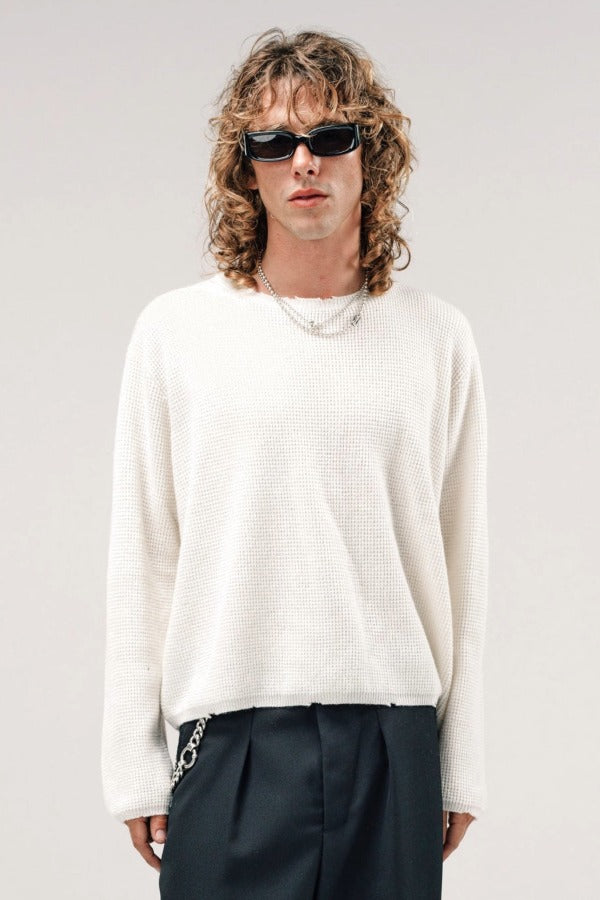 Front view of blanc friends pullover sweater on model wearing grey pants, against a white background.