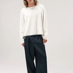 Alternate front view of blanc friends pullover sweater on model wearing grey pants and boots, against a white background.