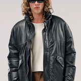 Front view of brown leather puffa jacket on model wearing white shirt and brown pants, against a white background.