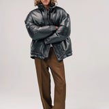 Alternate front view of brown leather puffa jacket on model wearing white shirt and brown pants with boots, against a white background.