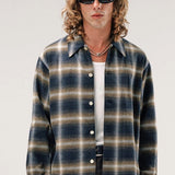 Front view of olive check logan ombre ls shirt on model wearing white shirt and grey pants, against a white background.