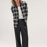 Alternate front view of olive check logan ombre s shirt on model wearing white shirt, grey pants and boots, against a white background.