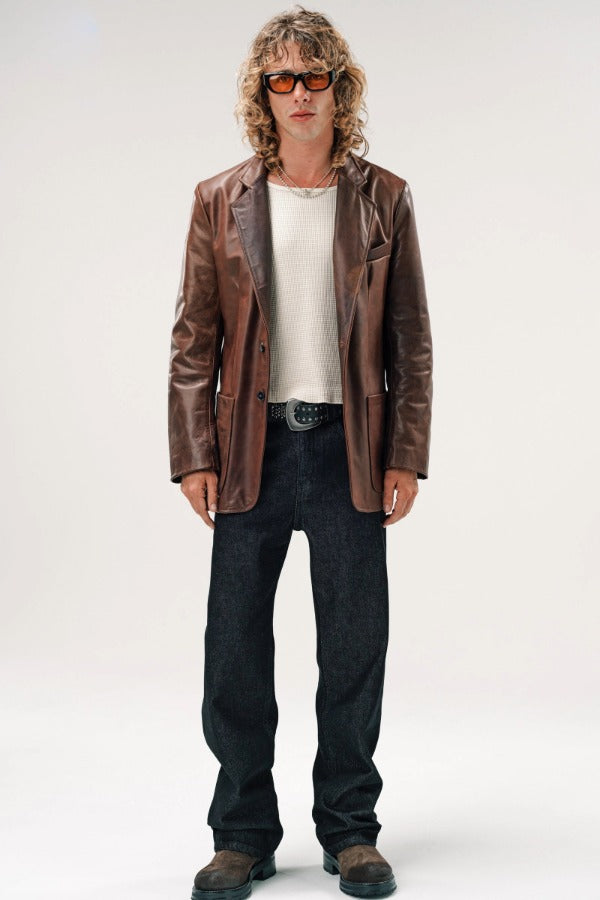 Alternate front view of brown saico jacket on model wearing white shirt, jeans and boots, against a white background.