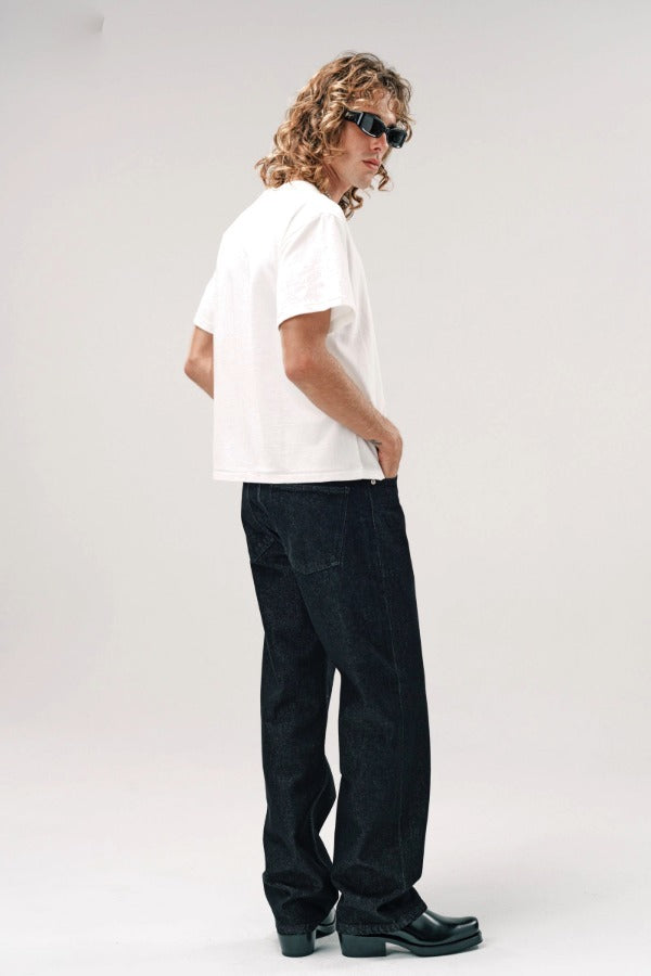 Side view of vintage white slappy pocket tee on model wearing jeans and boots, against a white background.