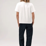 Back view of vintage white slappy pocket tee on model wearing jeans and boots, against a white background.
