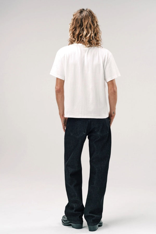 Back view of vintage white slappy pocket tee on model wearing jeans and boots, against a white background.