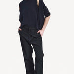Front view of titan midnight assk pants on model wearing navy top and boots, against a white background.