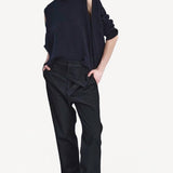 Front view of titan midnight assk pants on model wearing navy top and boots, against a white background.