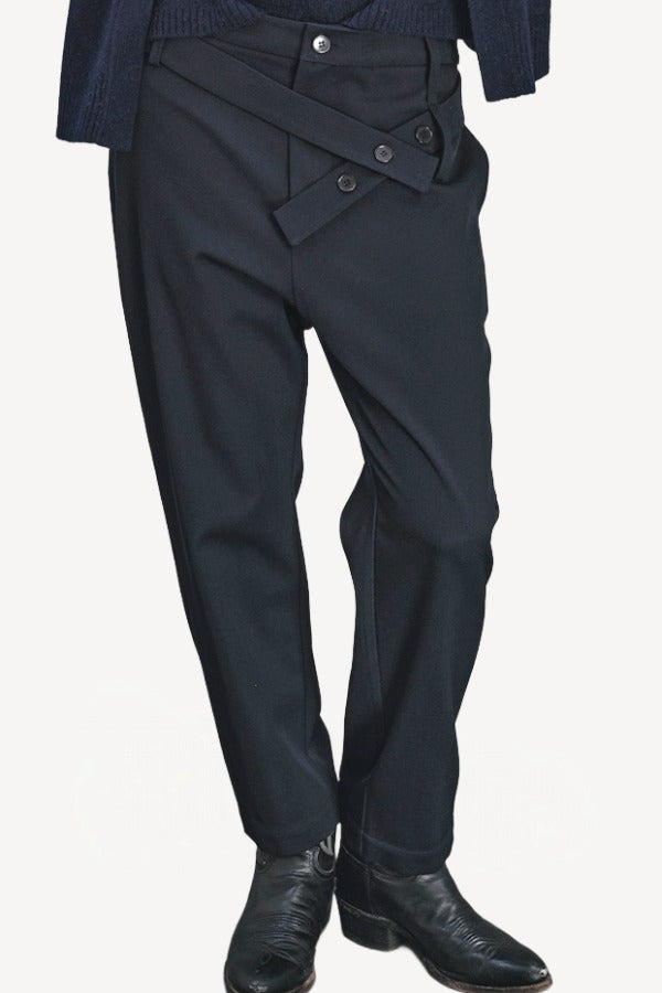 Front closeup view of titan midnight assk pants on model wearing navy top and boots, against a white background.