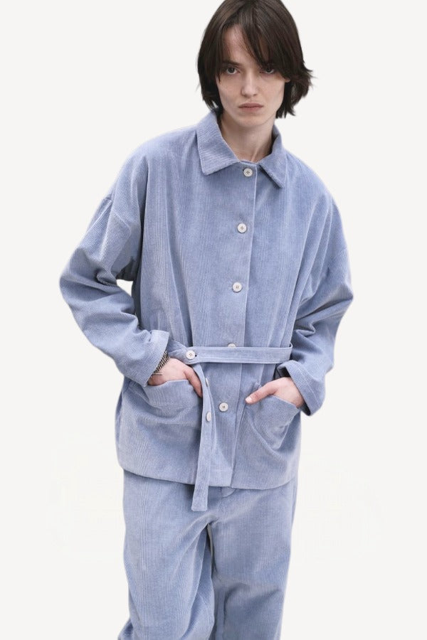 Front view of blue ice work jacket on model wearing blue ice pants, against a white background.