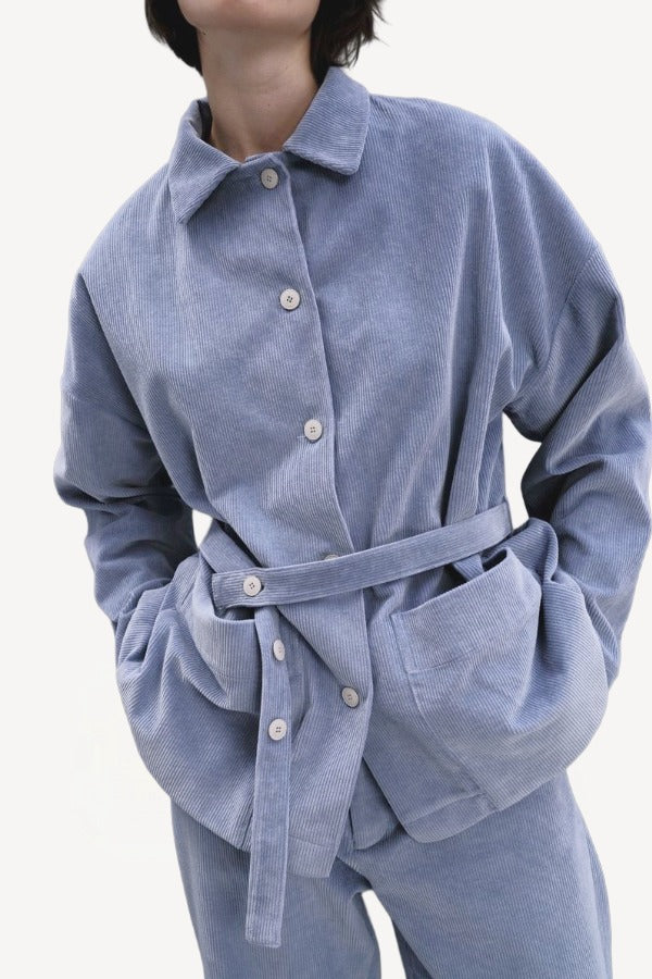 Front closeup view of blue ice work jacket on model wearing blue ice pants, against a white background.