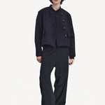Front view of titan midnight enes pants on model wearing navy jacket and boots, against a white background.