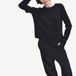 Front view of titan midnight enes pants on model wearing black top and boots, against a white background.