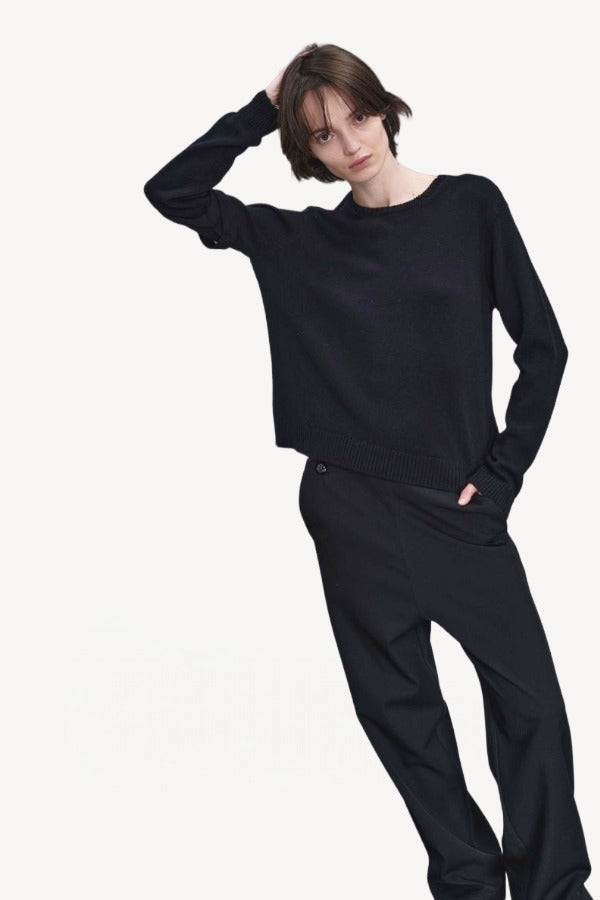 Front view of titan midnight enes pants on model wearing black top and boots, against a white background.