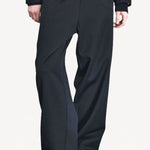 Front closeup view of titan midnight enes pants on model wearing navy jacket and boots, against a white background.