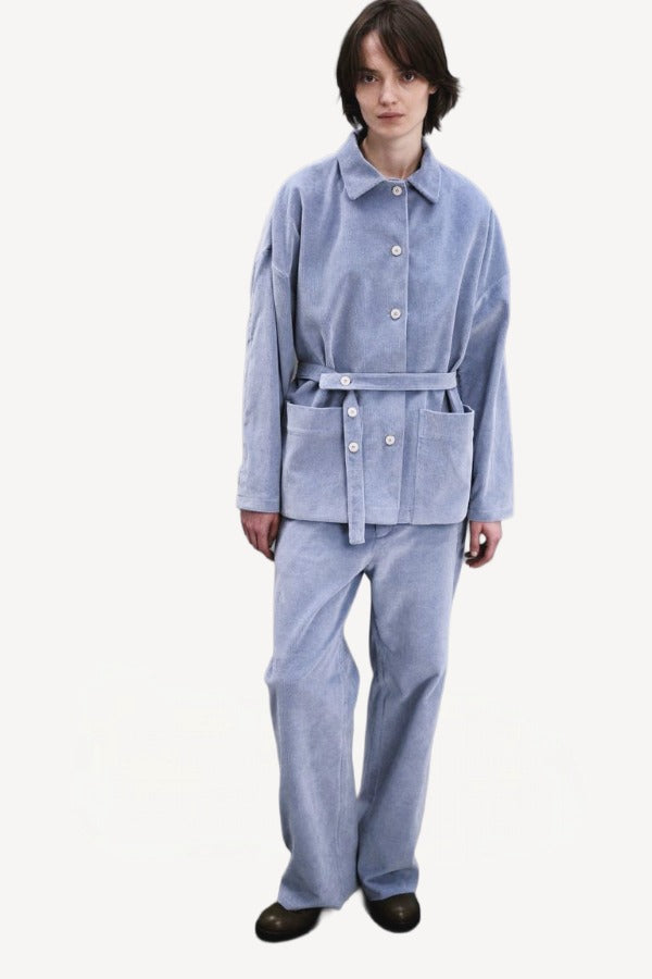 Front view of blue ice esra marine pants on model wearing blue ice jacket and boots, against a white background