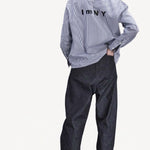 Alternate back view of blue white stripe imny shirt on model wearing dark jeans and boots, against a white background.