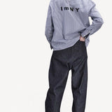 Alternate back view of blue white stripe imny shirt on model wearing dark jeans and boots, against a white background.