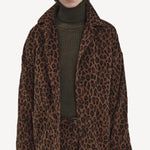 Alternate front view of leopard work jacket on model wearing green sweater and leopard pants, against a white background.