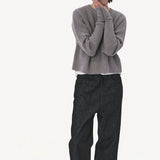 Front view of denim M pants on model wearing grey sweater and boots, against a white background.