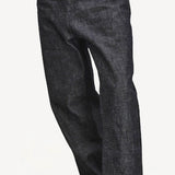 Front closeup view of denim M Pants on model wearing stripe shirt and boots, against a white background.