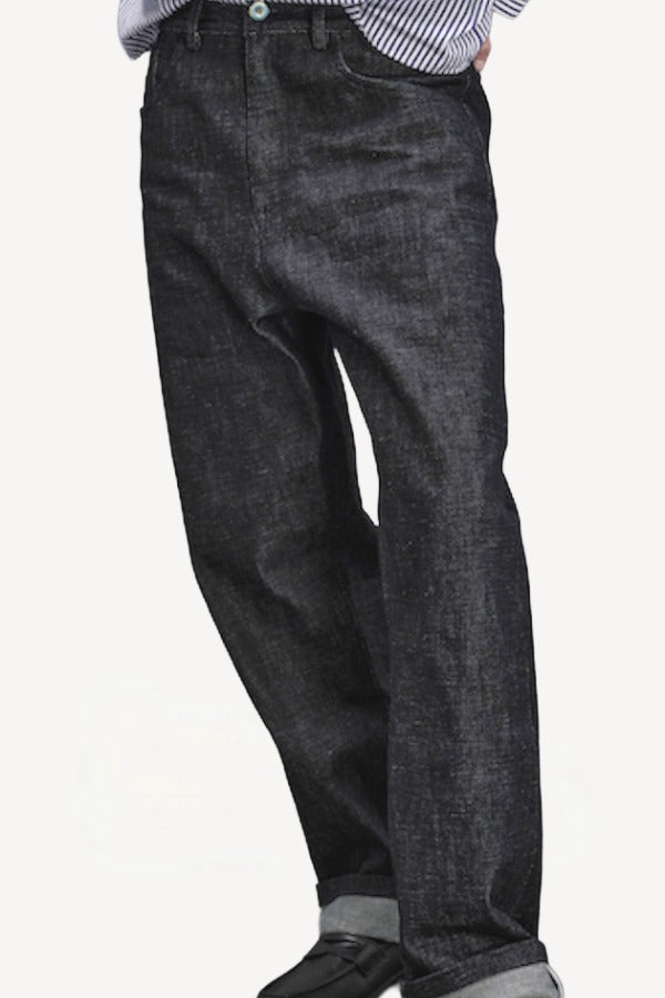 Front closeup view of denim M Pants on model wearing stripe shirt and boots, against a white background.