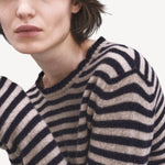 Front closeup view of navy/oat sibs stripe sweater on model, against a white background.