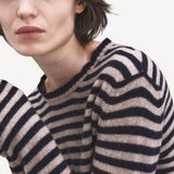 Front closeup view of navy/oat sibs stripe sweater on model, against a white background.
